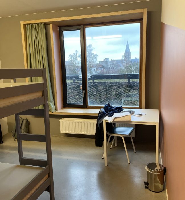hostel dorm with a bunk bed and a desk